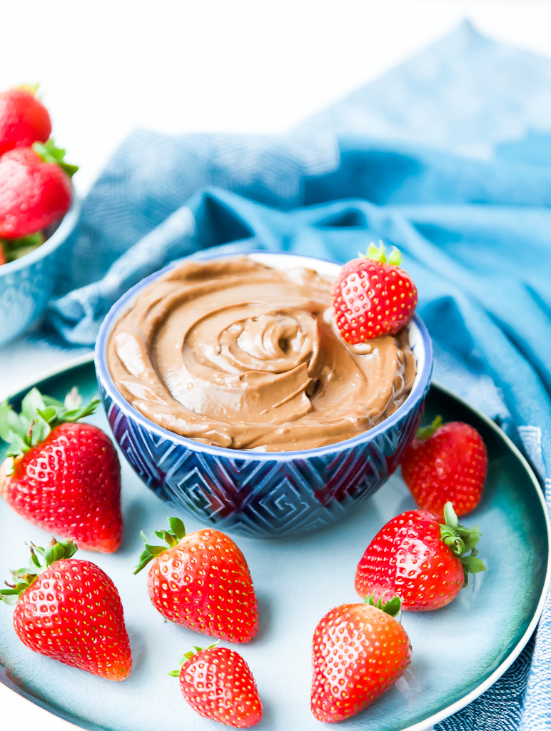 A bowl of vegan chocolate mousse with a strawberry on top.