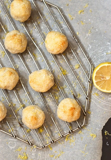 A tray of toasted lemon coconut macaroons with lemon slices around it.