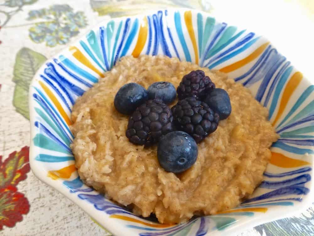 A bowl of creamy paleo oatmeal topped with blackberries and blueberries. 