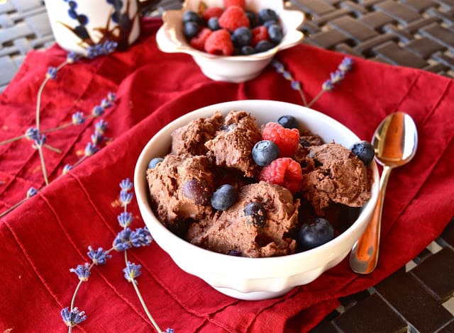 A bowl of double berry chocolate ice cream topped with fresh blueberries and raspberries. 