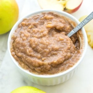 A bowl of sugar free applesauce with a spoon in it.