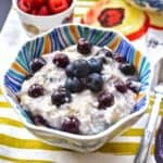 A bowl of oatmeal topped with fresh blueberries.