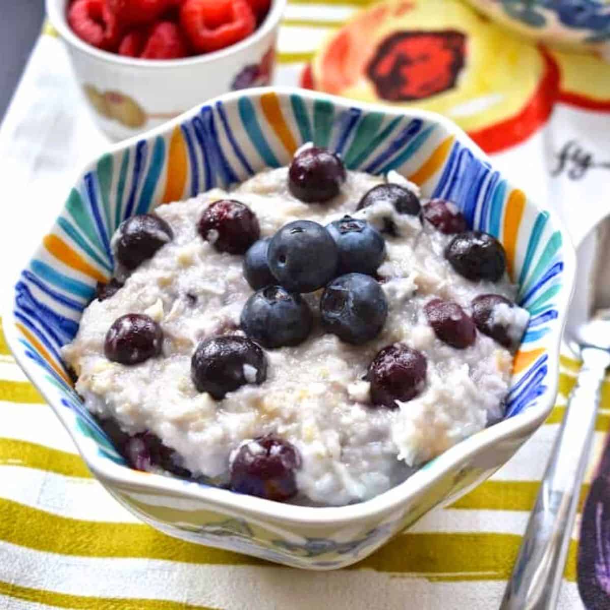 A bowl of oatmeal topped with fresh blueberries.