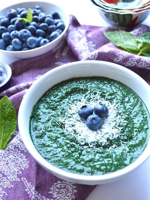 A mint smoothie bowl topped with blueberries.