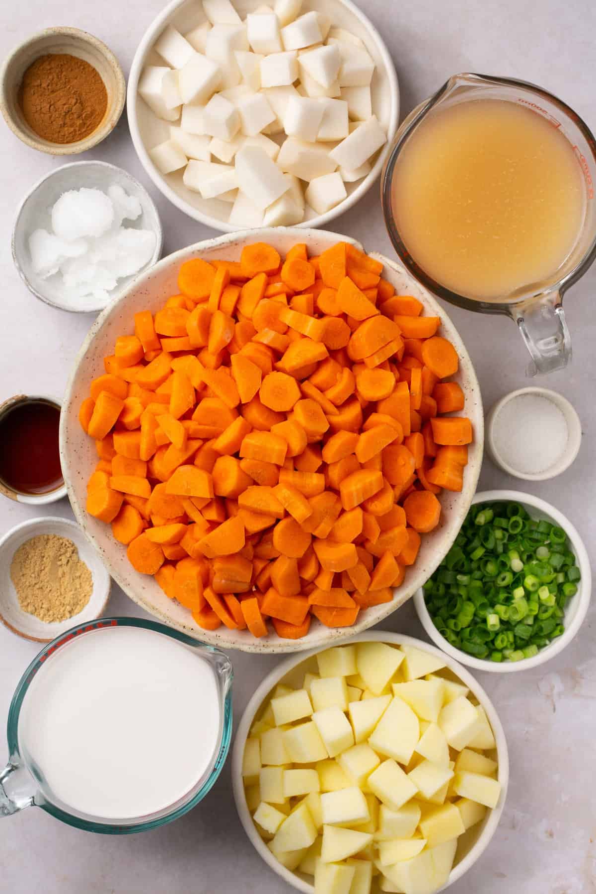 The ingredients needed to make a carrot and turnip soup, separated into bowls.