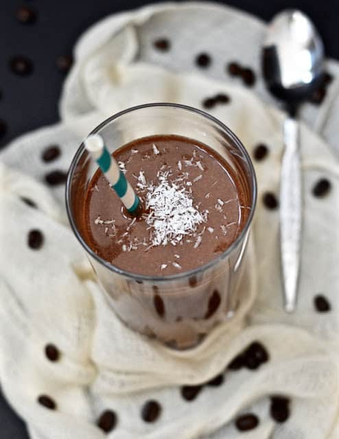 A glass of chocolate mocha smoothie with a straw in it.