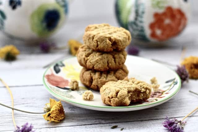A stack of three paleo ranger cookies on a plate. 