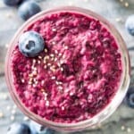 A jar of blueberry chia jam topped with a fresh blueberry and white chia seeds.