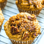 Banana pecan muffins with streusel topping on a baking rack.