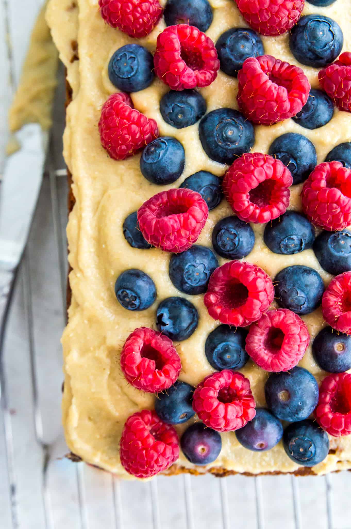 A loaf of paleo carrot cake banana bread topped with blueberries and raspberries.