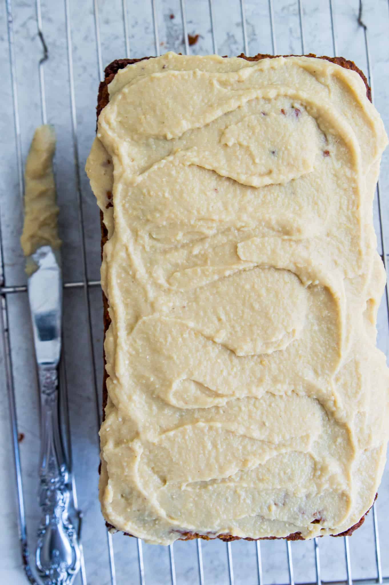 A loaf of bread with a thick white icing on top of it.