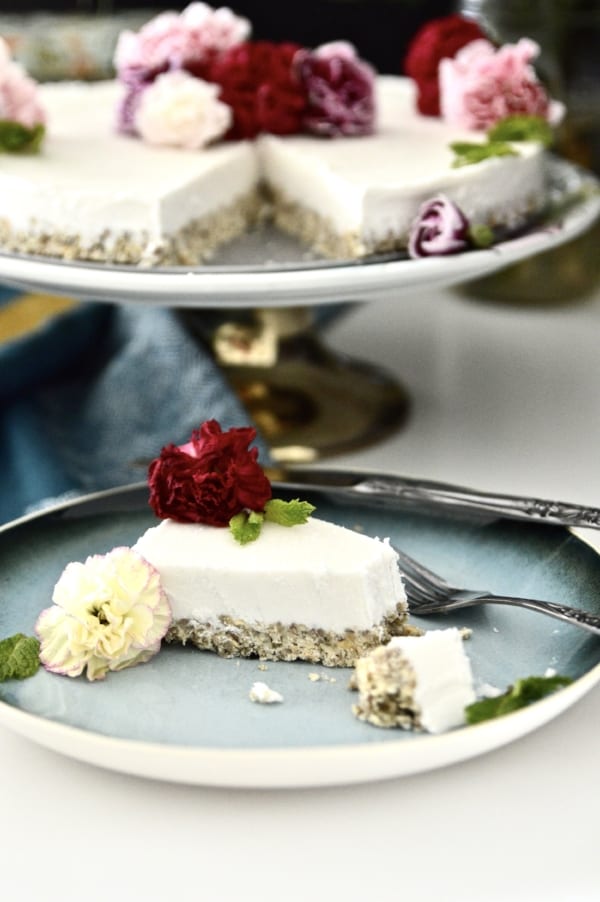 A piece of vegan mint ice cream cake on a plate with a bite out of it. 