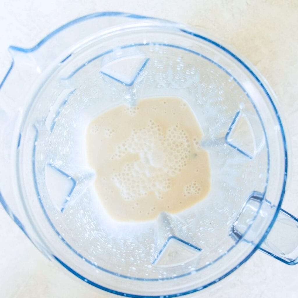 A blender with a white liquid in it.