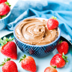 A bowl of chocolate avocado mousse topped with fresh strawberries.