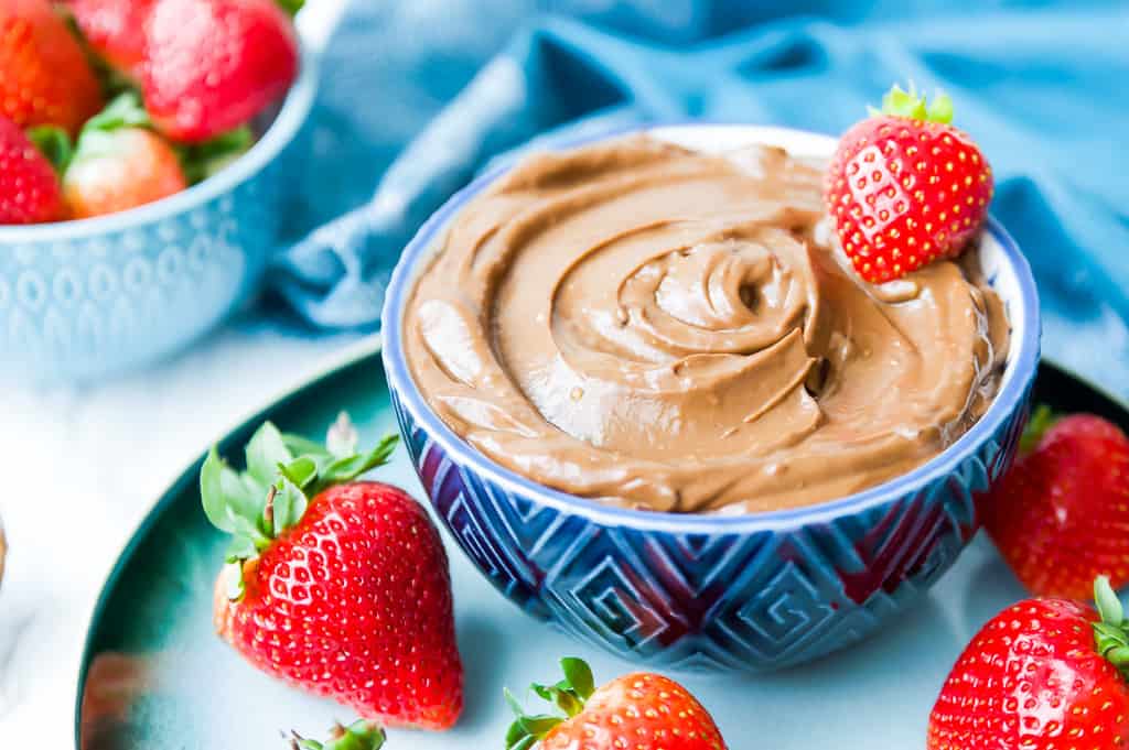 A bowl of chocolate avocado mousse with strawberries