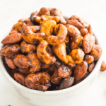 A bowl of sweet curry cashews and almonds.