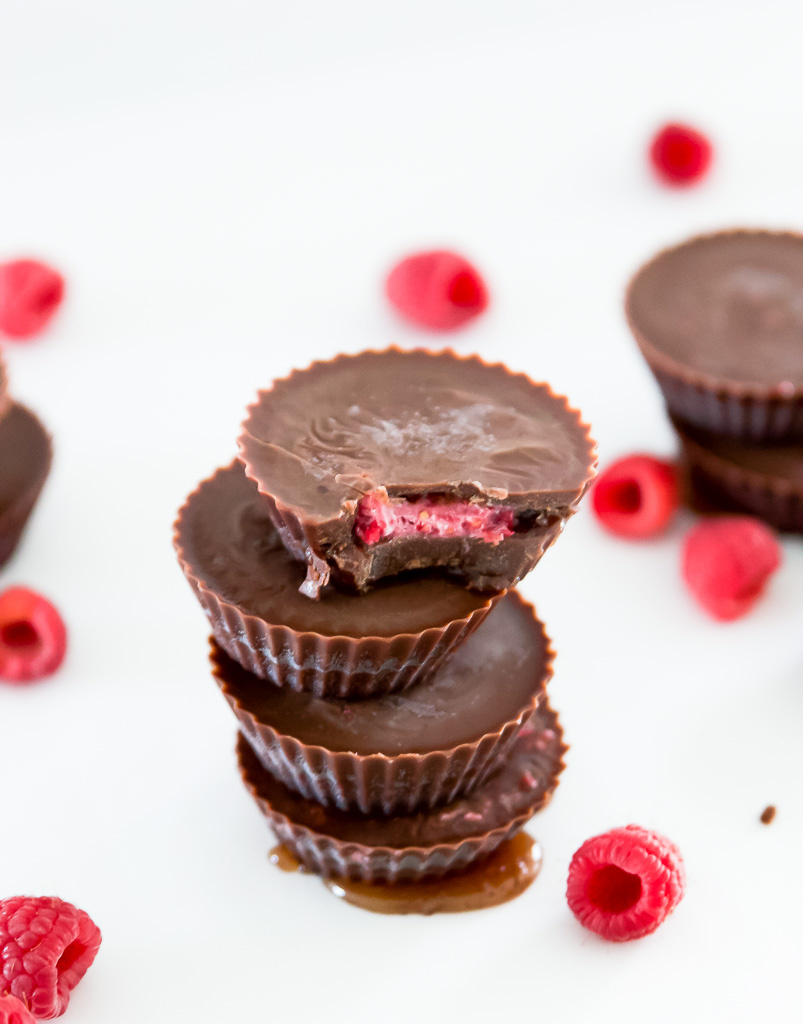 A tower of chocolate raspberry cups with a bite out of the top one