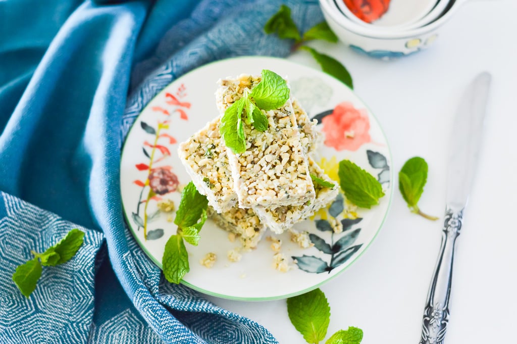 A stack of mint crunch bars on a plate with mint leaves on top for garnish.