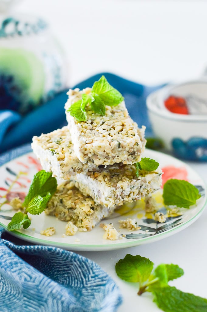 A stack of 4 paleo mint nut crunch bars on a floral pattern plate.