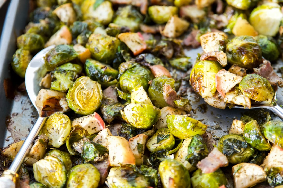 A pan full of roasted Brussel sprouts with bacon and apples 