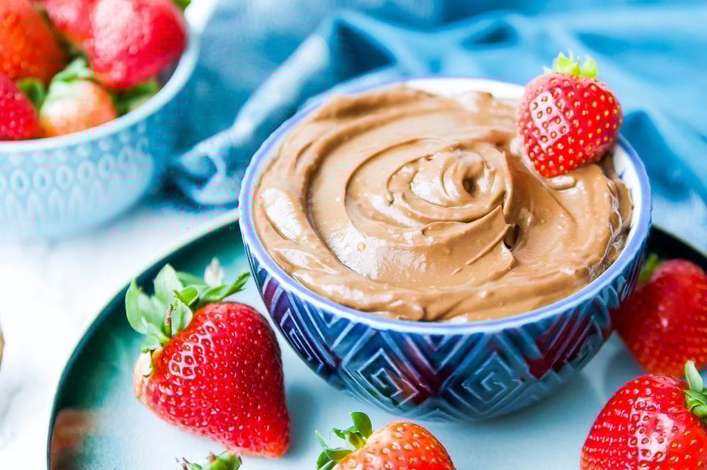 A bowl of avocado chocolate mousse with strawberries on top.