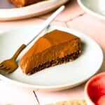 A slice of chocolate torte on a plate with a fork next to it.