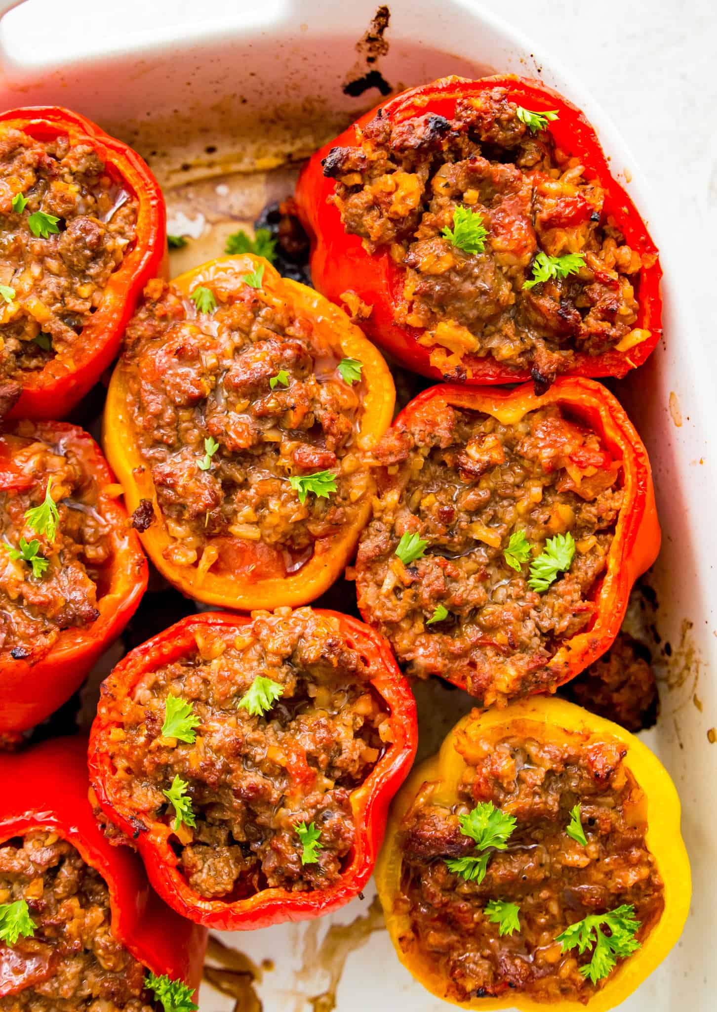 A baking pan full of cooked Whole30 stuffed peppers garnished with cilantro