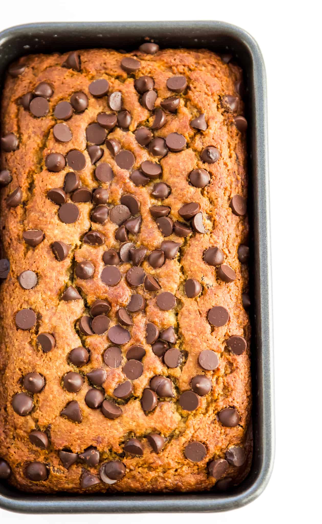 A loaf of gluten free chocolate chip banana bread in a bread pan