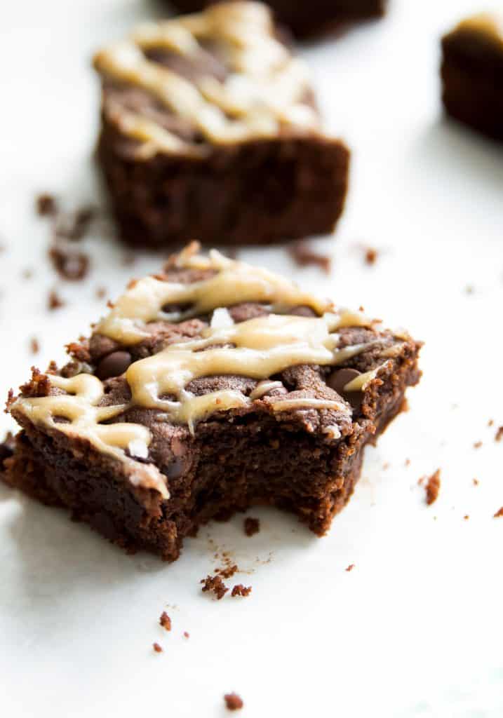 Gluten free brownies with a caramel drizzle and a bite out of one brownie