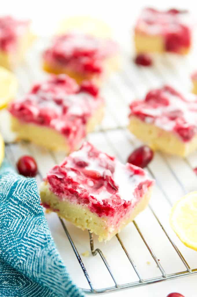 Pieces of gluten free lemon bars with cranberry on a wire rack