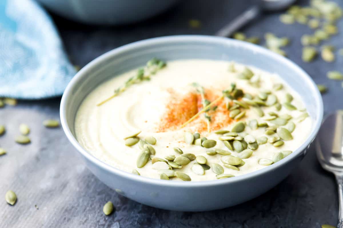 A bowl of vegan cauliflower soup with paprika and pumpkin seeds