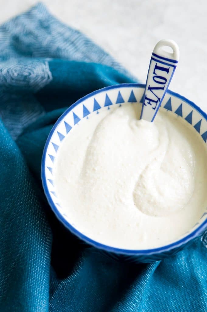 A bowl of dairy free sour cream with a spoon
