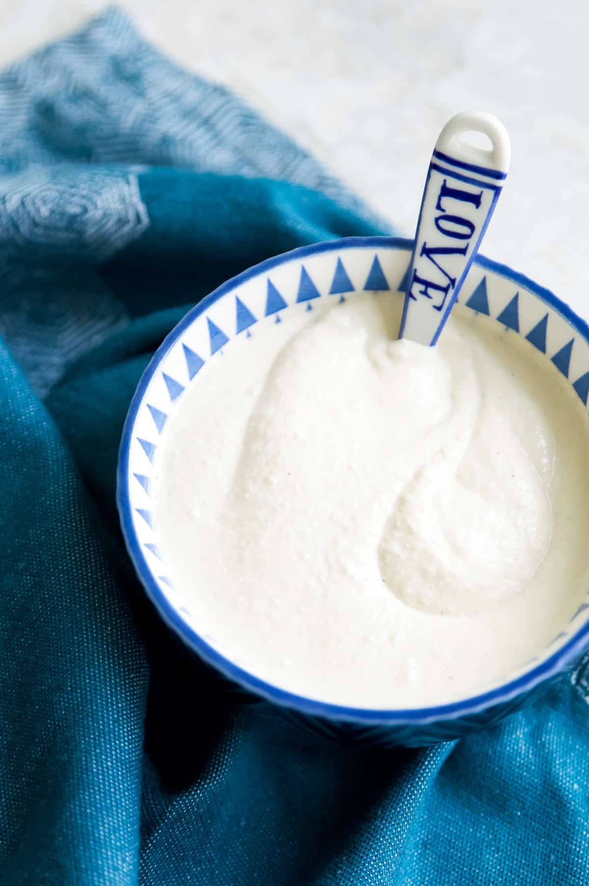 A bowl of dairy free sour cream with a spoon in it.
