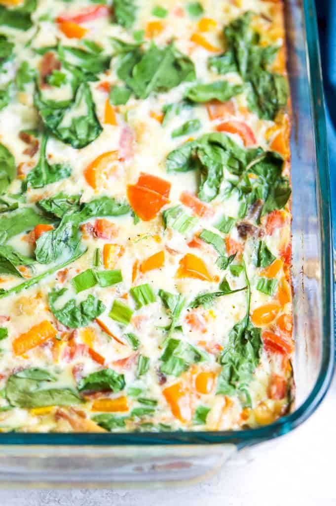 A bacon and vegetable egg casserole in a baking dish