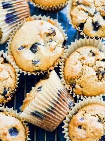 A batch of paleo blueberry muffins on a baking rack.
