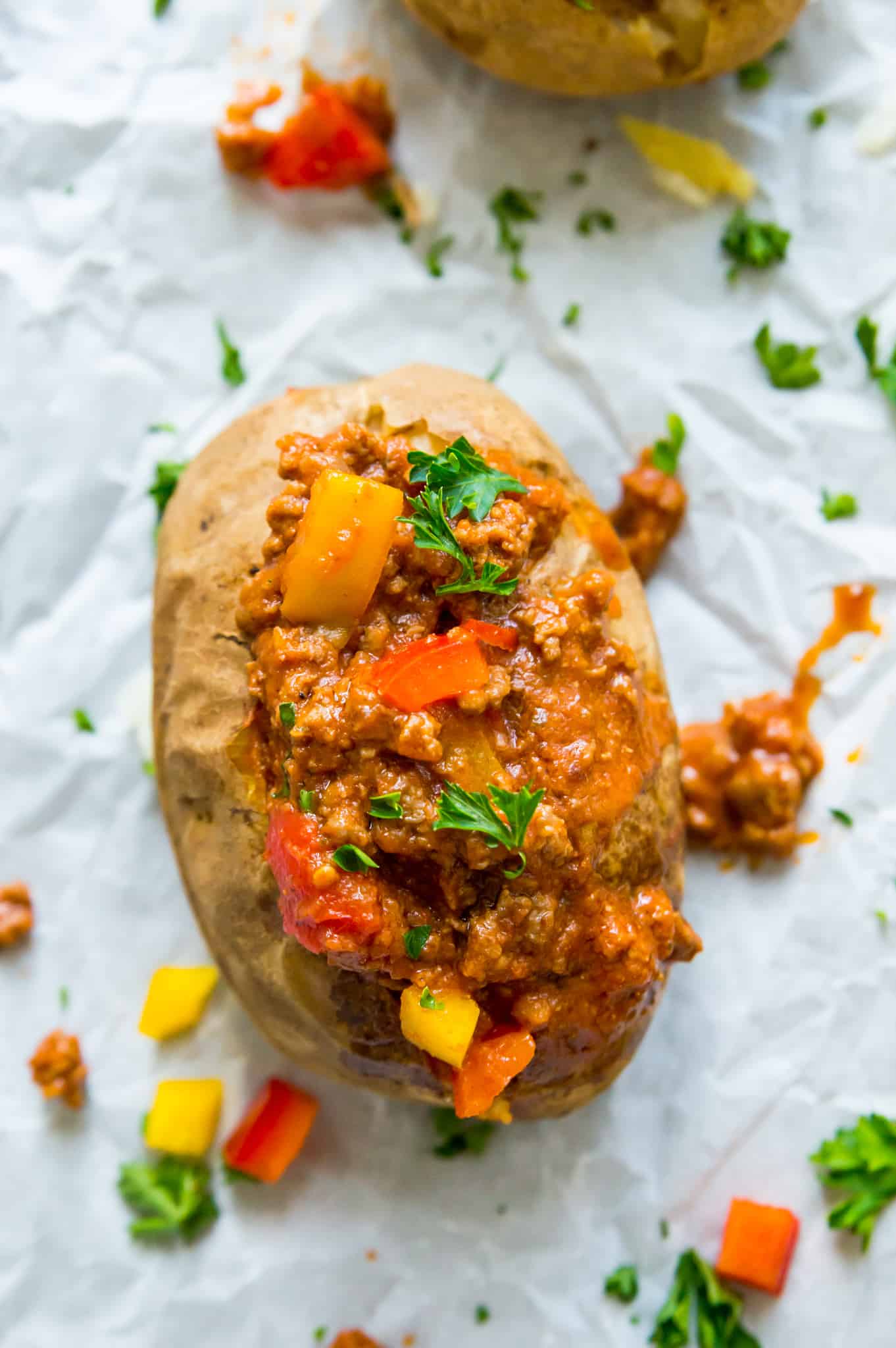 A healthy sloppy Joe on a baked potato garnished with parsley