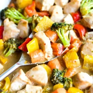 A pan of teriyaki chicken and vegetables with a serving spoon in it.