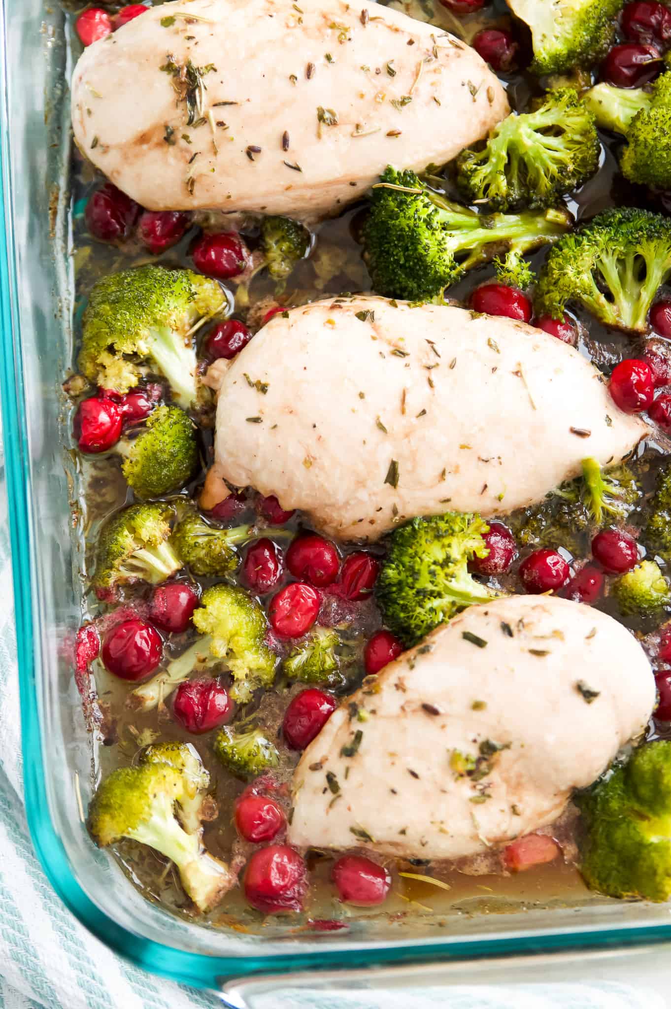 Cooked chicken, broccoli and cranberries in a baking dish.