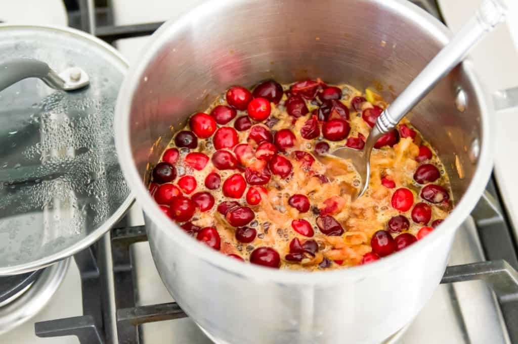 A pot filled with cooking apples and cranberries 