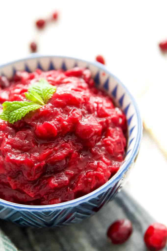 Bowl of sugar free cranberry sauce with cranberries around it 