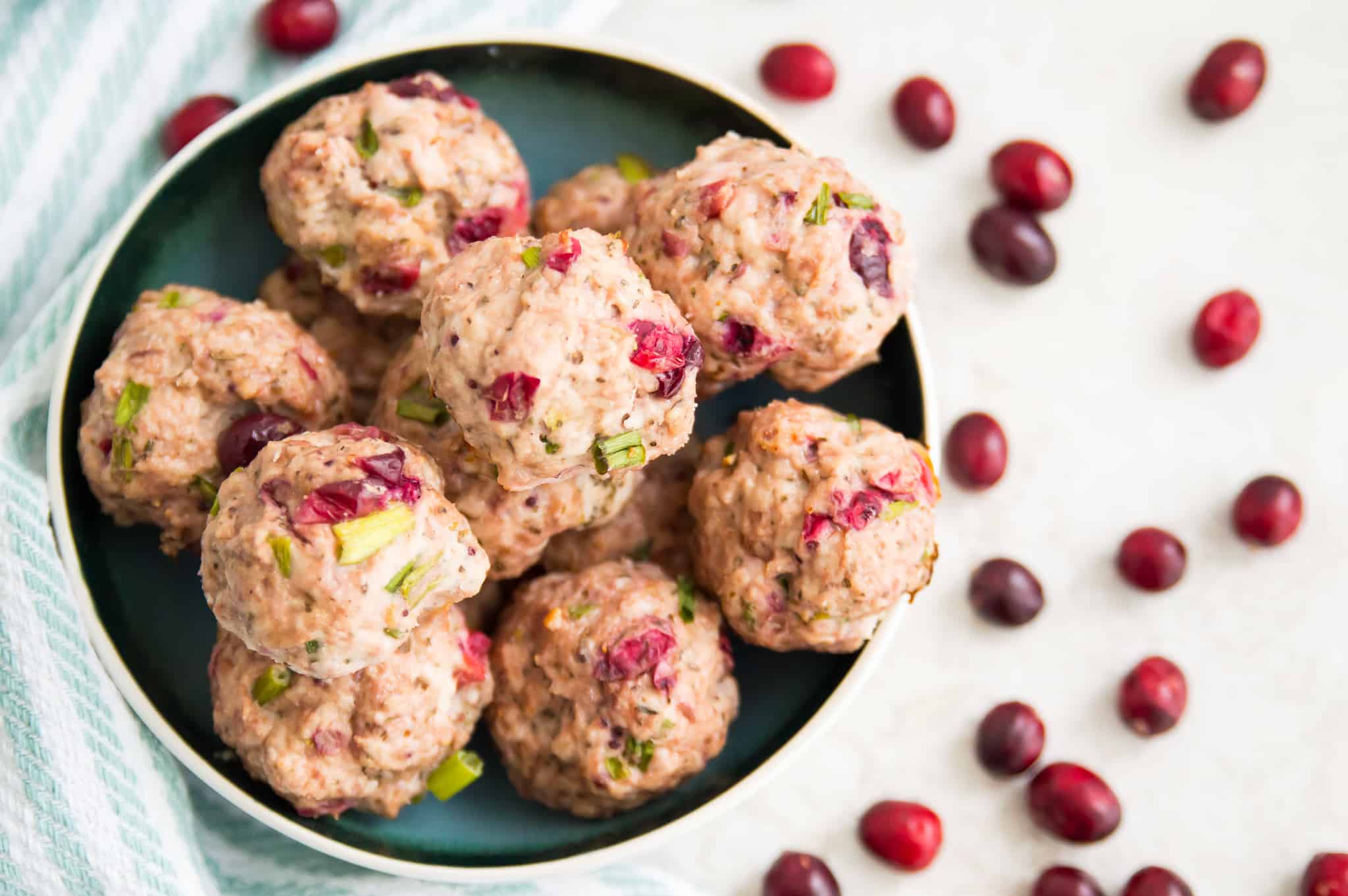 A bowl full of turkey meatballs with cranberry sauce in them.