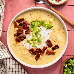 A bowl of creamy dairy free potato soup topped with bacon bits and chopped green onion.