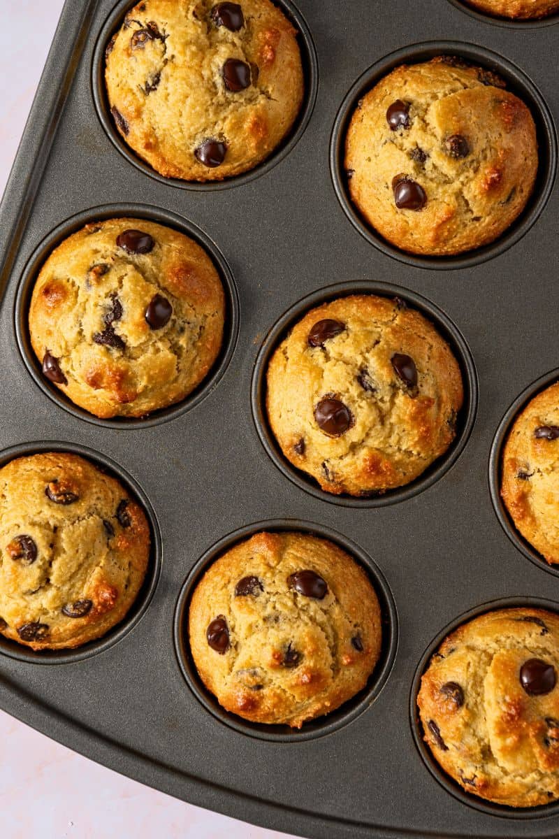 A batch of banana chocolate chip muffins in a muffin tray.