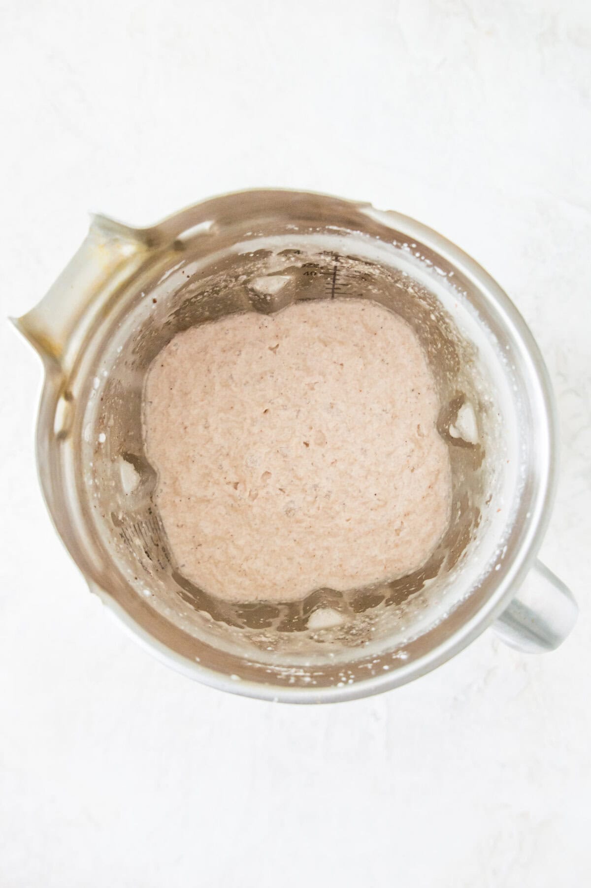A blender with a white creamy liquid in it.