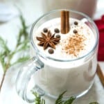 A mug of vegan eggnog garnished with star anise and ground cinnamon.