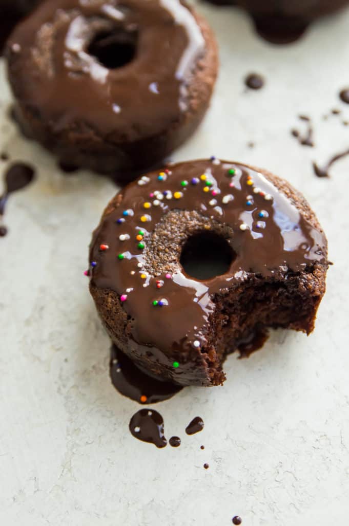 A dairy free chocolate donut with icing and sprinkles 