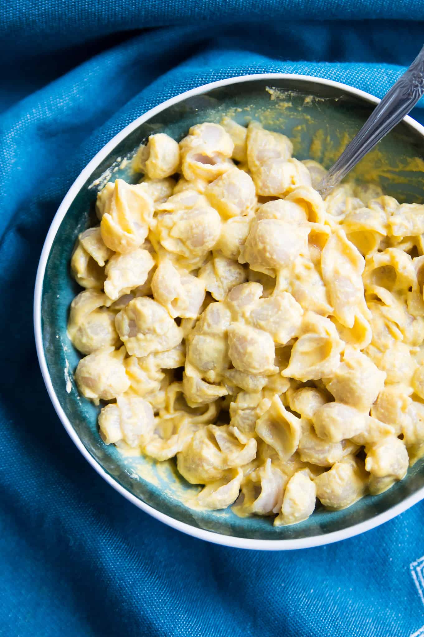 A large bowl of dairy free Mac and cheese with a spoon in it.