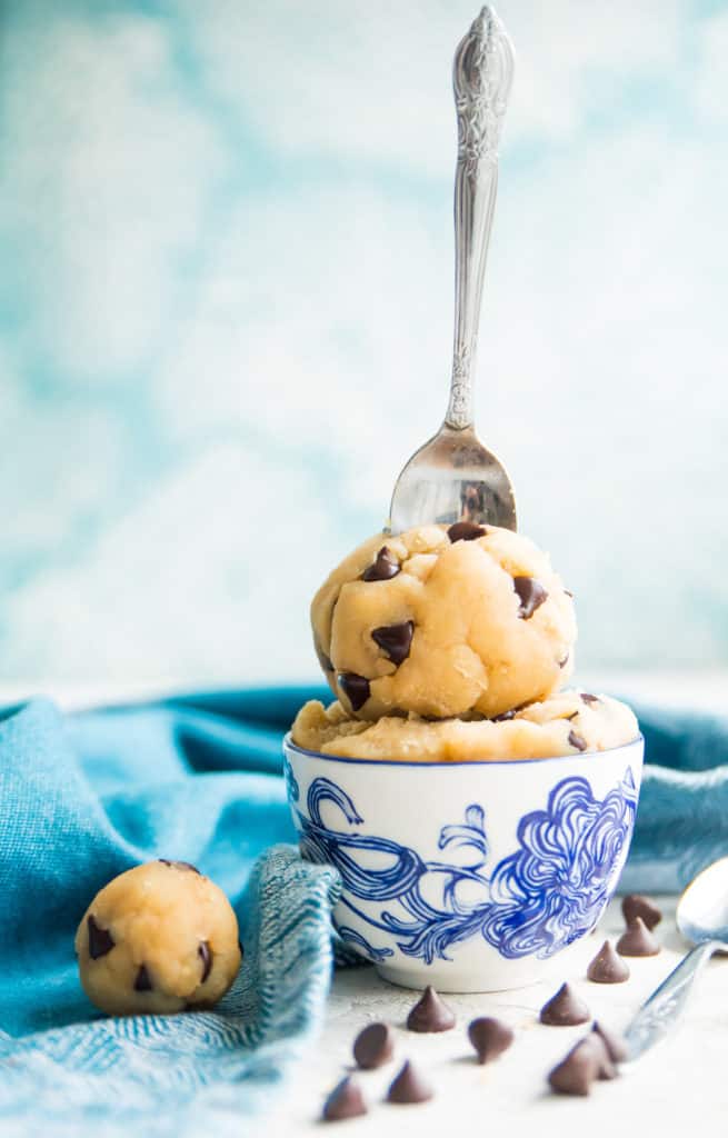 A bowl of edible cookie dough with a spoon