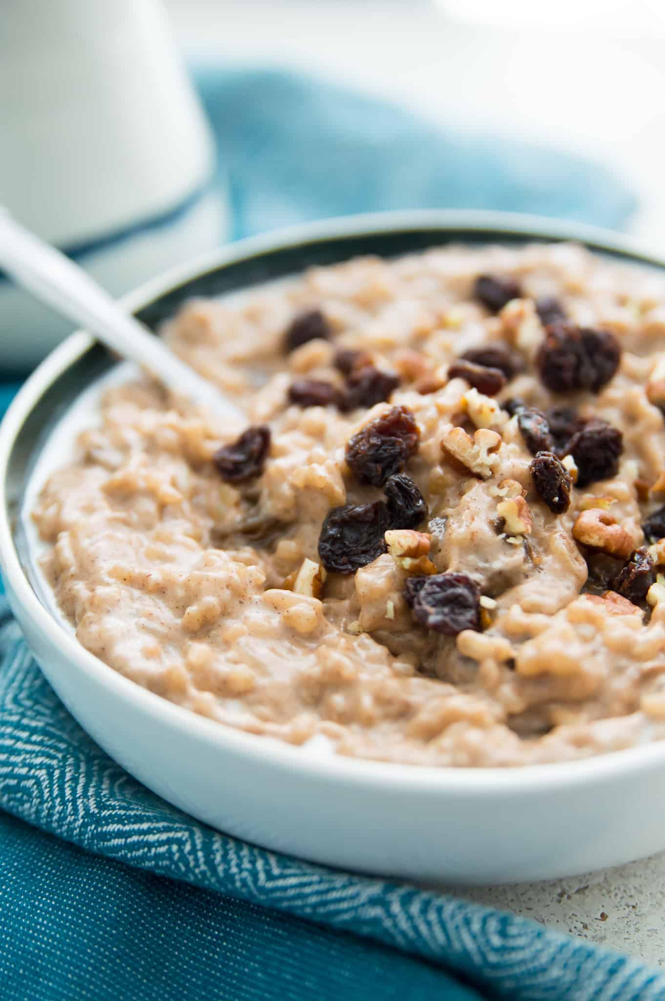 A bowl of dairy free rice pudding with raisins and pecans on top.