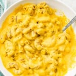 A bowl of dairy free Mac and cheese with a spoon in it.